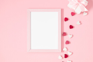 Valentine's Day composition. Photo frame and hearts on pastel pink background. Wedding. Birthday. Happy woman's day. Mothers Day. Flat lay, top view, copy space