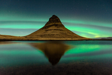 Spectacular reflection of the Kirkjufell mountain under the Northern Lights  (Aurora Borealis) and...