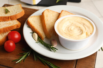 Wooden board with box of processed cheese, toasts and vegetables on on white tile background