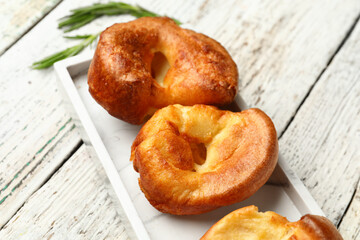 Plate with tasty Yorkshire pudding on light wooden background