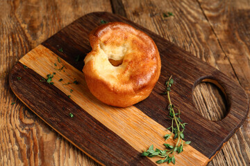 Board with tasty Yorkshire pudding on wooden background