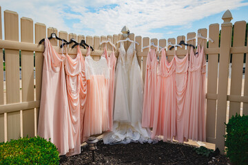 Bridal party dress lined up on a fence outside a event location
