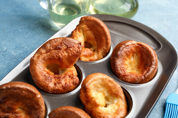 Baking tin with tasty Yorkshire pudding on blue background