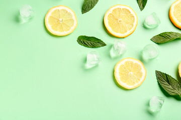 Lemon slices with ice cubes and mint on turquoise background