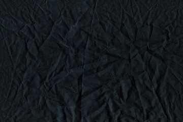 Fototapeta premium The texture of the wrinkled natural fabric is black and gray. Working fabric. Cotton crumpled rag, burlap. Abstract monochrome background.