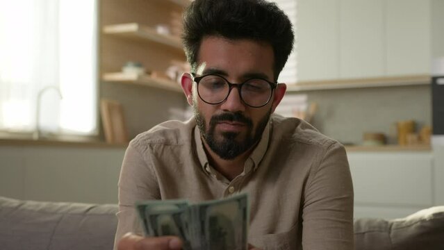 Sad upset Indian Arabian man stressed male businessman financial problem not enough money cash bankruptcy at home worry counting dollars domestic budget crisis poverty high bills trouble with finances