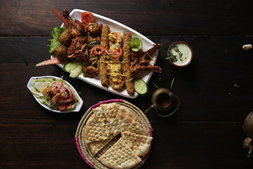 Chicken Kebab in tray with naan, youghrt, salad restaurant style selective focus, topview