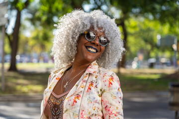 Stylish, smiling afro lady with grey afro hairstyle in sunny city