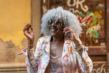 Grey-haired afro-american woman talking on cellphone.