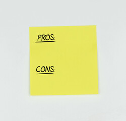 Yellow Post-it with the words Pros and Cons written in black, with a white background