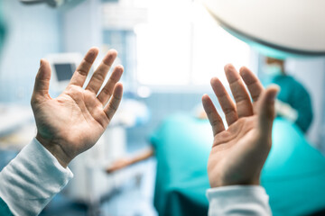 Closeup photo of clean washed hands of surgeon in operating room. Unrecognizable surgeon showing...