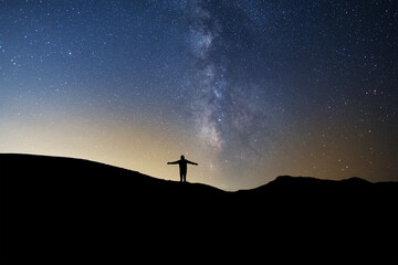Silhouette  standing on the hill, on the milky way galaxy background.