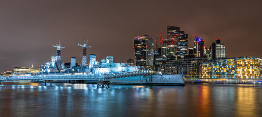 Fototapeta na wymiar Night view of HMS Belfast, a town-class light cruiser that was built for the Royal Navy, moored as a museum ship on the River Thames in London