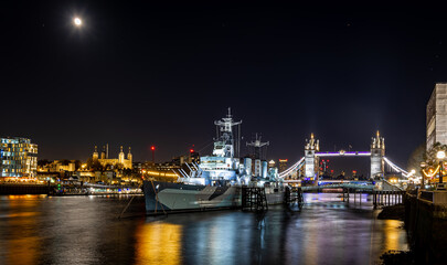 Fototapeta na wymiar Night view of HMS Belfast, a town-class light cruiser that was built for the Royal Navy, moored as a museum ship on the River Thames in London