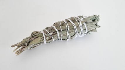 Bundle of dry white sage, Salvia officinalis, isolated on a grey background.