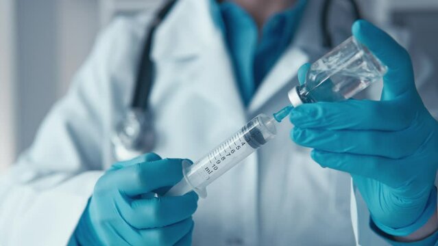 An infectious disease doctor, preparing a syringe with an antiviral drug, emphasizes the need for proper immunization to combat infectious diseases.