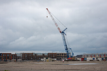 Fototapeta na wymiar Lifting crane for building new construction houses in the ¨
