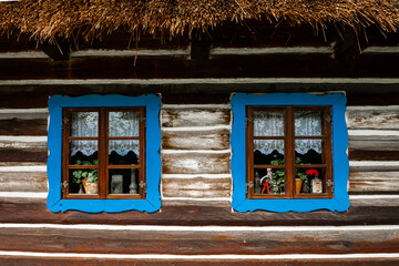 kolorowe okna starej wiejskiej chaty krytej strzechą  - obrazy, fototapety, plakaty
