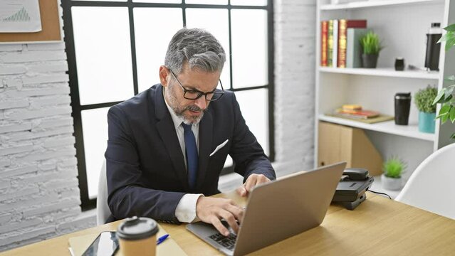 Heart attack strikes young grey-haired hispanic office worker - high-stress suffering amid business duties at indoor workplace