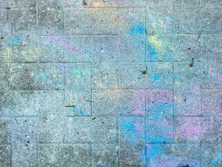 Paving stones from above with paint splatters and splatters of paint on them.