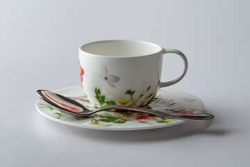 Coffee cup decorated with painted flowers with plate and teaspoon