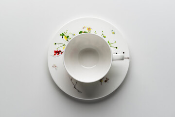 Empty teacup with saucer decorated with flowers