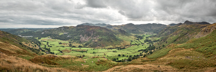 Fototapeta na wymiar Panorama of Great Landgdale valley from Blea Rigg with Coniston Old Man, Bowfell and the Langdale Pikes on the skyline, Lake District, UK