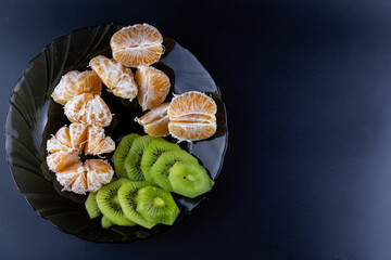 kiwi and tangerines on a plate