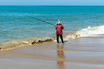 Thailand. Kao-Lak. A woman is fishing on the seashore.
