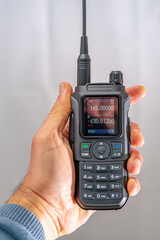 amateur radio walkie talkie portable triband held in the hand of a white man