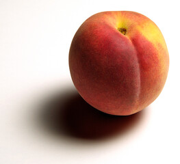 Whole peach with shadow on white background