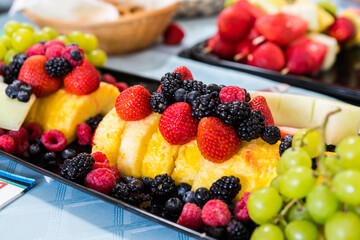 Colorful mixed fruit platter at a party. Plates of fresh fruits on a dessert table.