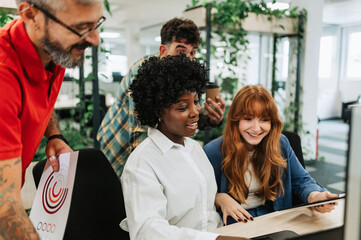 An interracial businesswoman is collaborating on project with team.