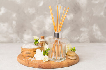 Spa composition with freesia flower and aroma diffuser on concrete background