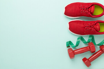 Sport equipment with tape measure on color background, top, view. Weight loss concept