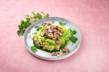 Traditional savoy cabbage lasagne with mashed potatoes and mushrooms served as a close-up on a design plate with text space