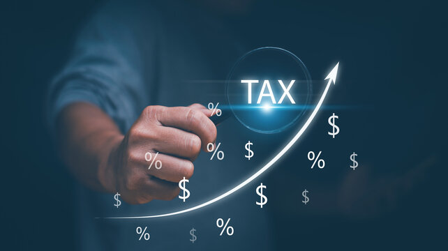 Finance and business concept, Businessman holding magnifier glass with increasing arrow for percentage of tax. Financial data analysis for tax assessment.