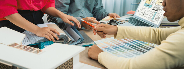 Cropped image of interior designer team discuss the material color while laptop displayed website...
