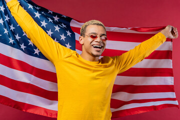 Happy man with national USA flag on red background. American patriot 4th of July