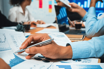 Diverse group of business analyst team analyzing financial data report paper on office table. Chart and graph dashboard by business intelligence analysis for strategic marketing planning Habiliment - obrazy, fototapety, plakaty