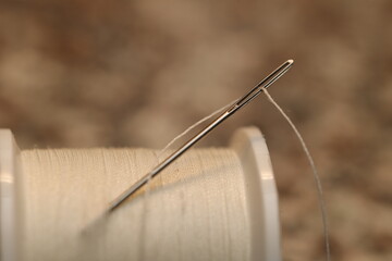 Close-up of a needle with thread against a blurred background