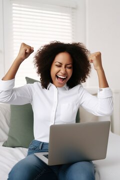 Ecstatic young African-American woman celebrating her online success