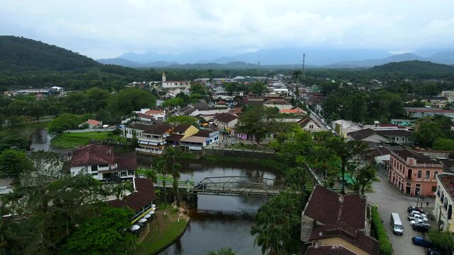 Aerial shot drone flies to the left with bridge over main river in Morretes