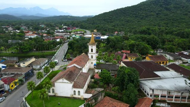 Aerial shot drone orbits to the right around town's main church in Morretes
