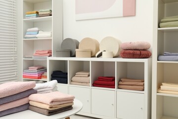 Different colorful bed linens and decorative boxes on display in home textiles store