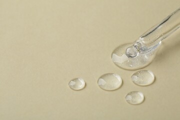 Pipette with samples of cosmetic serum on beige background. Space for text