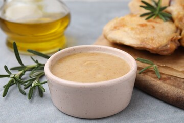 Delicious turkey gravy and rosemary on grey table, closeup