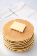 Delicious pancakes with butter on table, closeup
