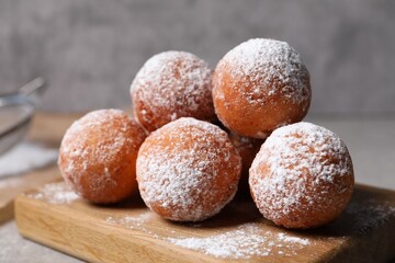 Delicious sweet buns with powdered sugar on table, closeup