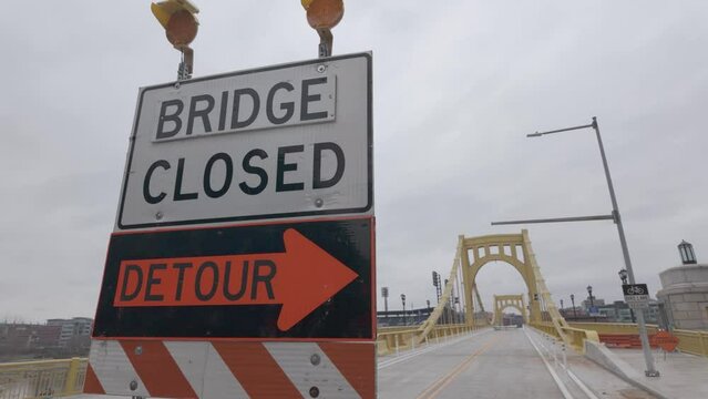 A dolly shot of the road closed sign on the 6th Street Bridge over the Allegheny River in downtown Pittsburgh, Pennsylvania. The Roberto Clemente Bridge was closed for renovations in 2023.  	